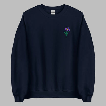 Image: A beautifully embroidered iris flower crewneck sweatshirt in a soft, relaxed fit. This custom floral design adds an elegant touch to any wardrobe, making it a meaningful Mother's Day gift or a thoughtful present for nature lovers. The intricate embroidery captures the essence of the bearded iris, creating a timeless piece that celebrates botanical beauty and personal style, by jaecrece.