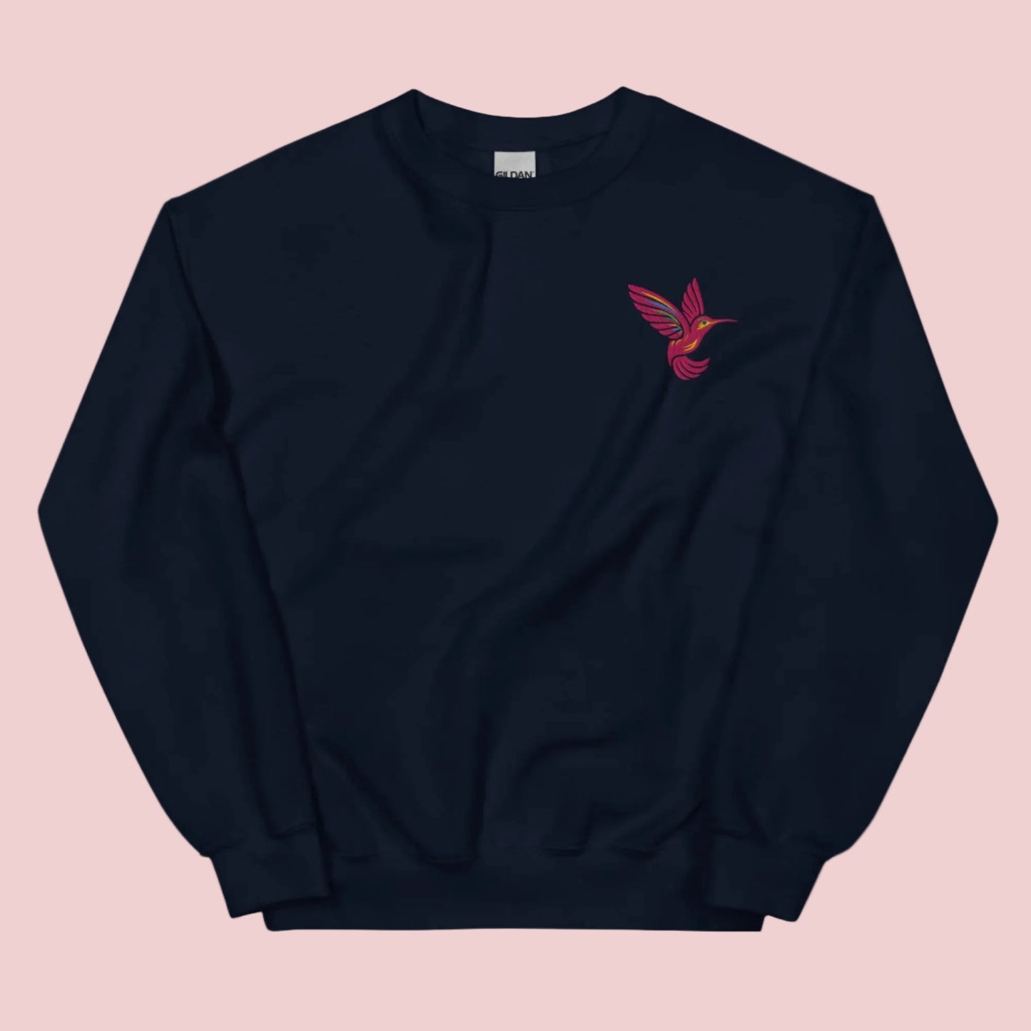 Embroidered hummingbird sweatshirt on Gildan 18000 crewneck featuring detailed bird stitching on soft cotton blend fabric. Cozy unisex pullover designed for everyday comfort and casual styling. Nature inspired sweatshirt perfect for bird lovers, garden aesthetic outfits, and cottagecore style. Ideal for women, moms, and gift giving. Available in sizes S to 5XL for relaxed fit layering and year round wear.