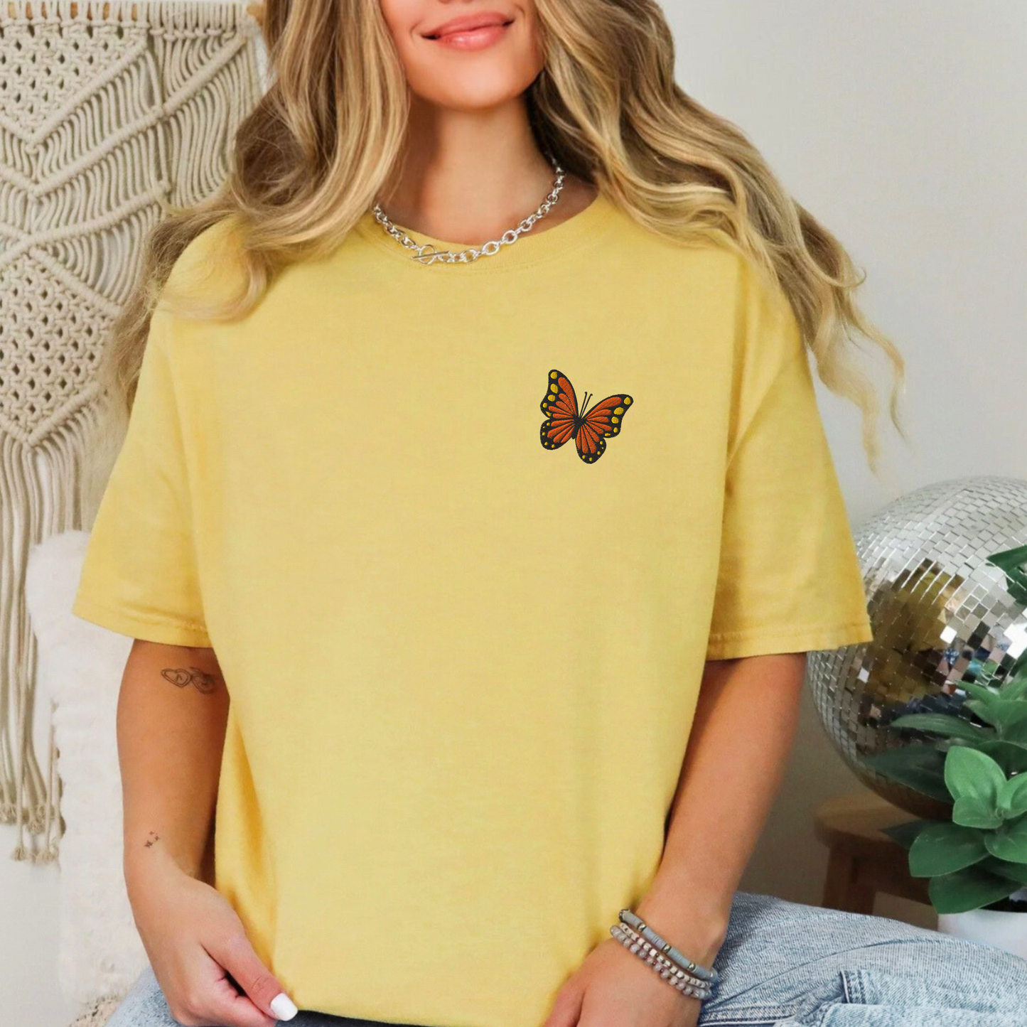 Image: Yellow comfort color t-shirt with butterfly embroidery styled with denim, making a trendy outfit for spring break, concerts, or sunny weekend markets. This embroidered tee channels spring vibes and y2k softness, making it a great choice for teens and young adults looking for aesthetic layering basics with a dreamy feel, by jaecrece.