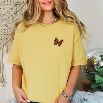 Image: Yellow comfort color t-shirt with butterfly embroidery styled with denim, making a trendy outfit for spring break, concerts, or sunny weekend markets. This embroidered tee channels spring vibes and y2k softness, making it a great choice for teens and young adults looking for aesthetic layering basics with a dreamy feel, by jaecrece.