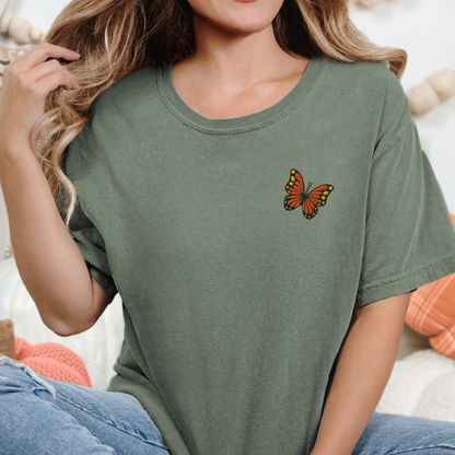 Image: Embroidered monarch butterfly tee on a woman, showcasing soft fabric and attention to detail. This cottagecore inspired shirt is great for teachers, moms, and naturalists who want wearable nature. Perfect for field trips, garden tours, or simply enjoying a sunny day in comfort and style, by jaecrece.