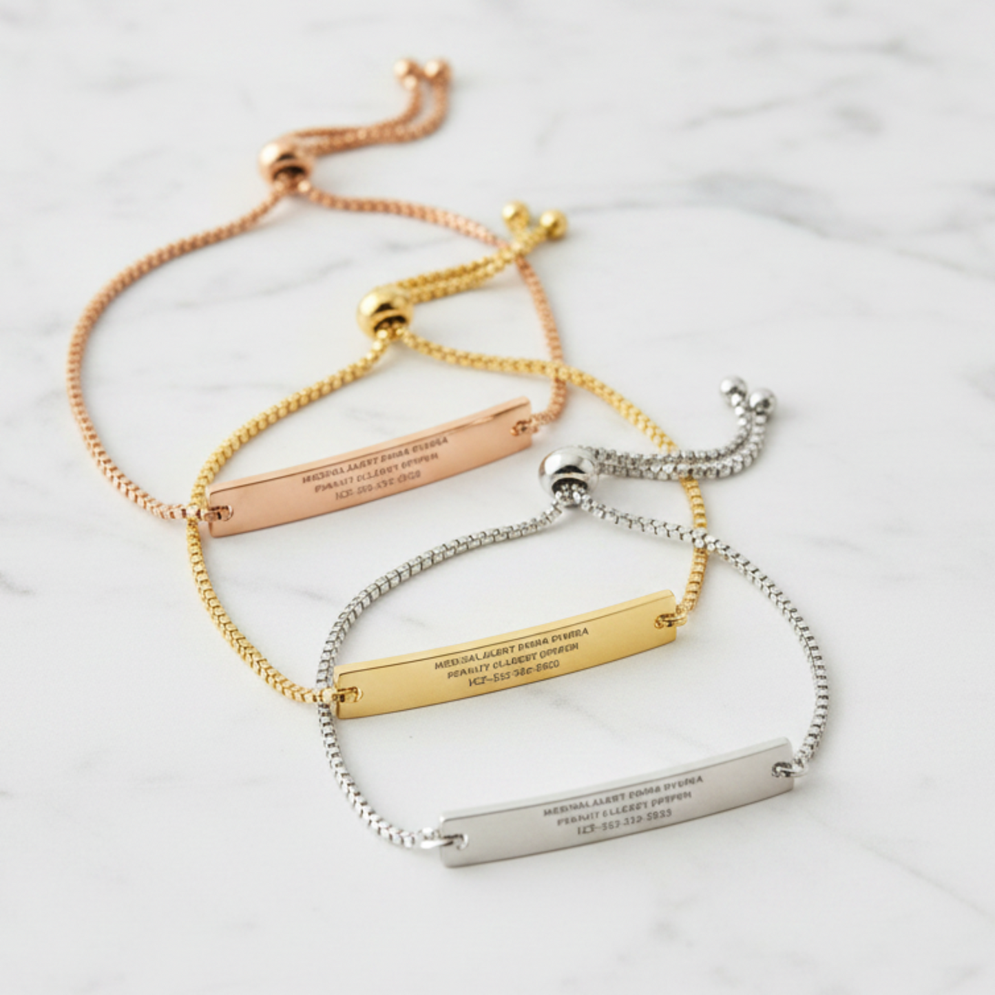 Three adjustable bar bracelets with engraved names, emergency medical information and phone numbers, shown in rose gold, yellow gold, and silver metal finishes on a light cream background.