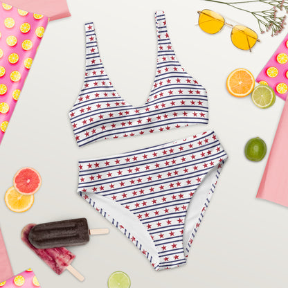 Patriotic high waisted bikini featuring an all over red star and blue stripe print. The swimsuit includes a supportive scoop neck top and coordinating high waisted bottoms designed for a comfortable and flattering fit. The phrase Stars and Stripes Forever appears across the back, adding a playful patriotic touch to this classic summer swimwear design.