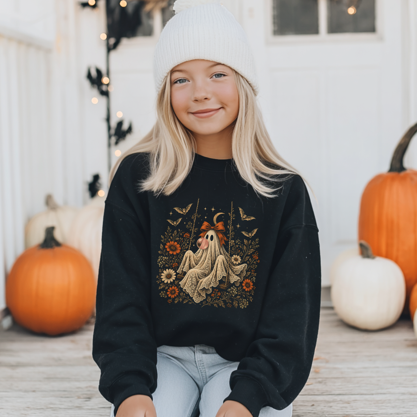 Girls black Halloween sweatshirt featuring a whimsical vintage ghost blowing a bubble with bubble gum, surrounded by orange flowers, bats, stars and delicate botanical details. Cute spooky fall clothing for girls who love ghosts, Halloween fashion, vintage gothic style and playful seasonal outfits.