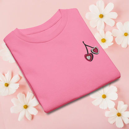 Charming girls tshirt with embroidered heart cherries on soft cotton fabric, offered in white, natural, and azalea. This easy to wear top is perfect for casual outfits, school days, and warm weather adventures. With its soft girl aesthetic and subtle coquette influence, it brings a sweet, playful look that still feels classic and versatile for everyday styling.