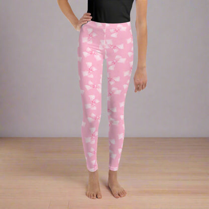 Image: These pink coquette leggings in youth sizes 8 to 20 feature adorable gingham bows scattered across soft, stretchy fabric. Ideal for girls who love all things girly, these leggings are perfect for ballet, weekend fun, or dressing up with friends. Their sweet design makes them a thoughtful gift for tweens and teens who adore unique style, by jaecrece.