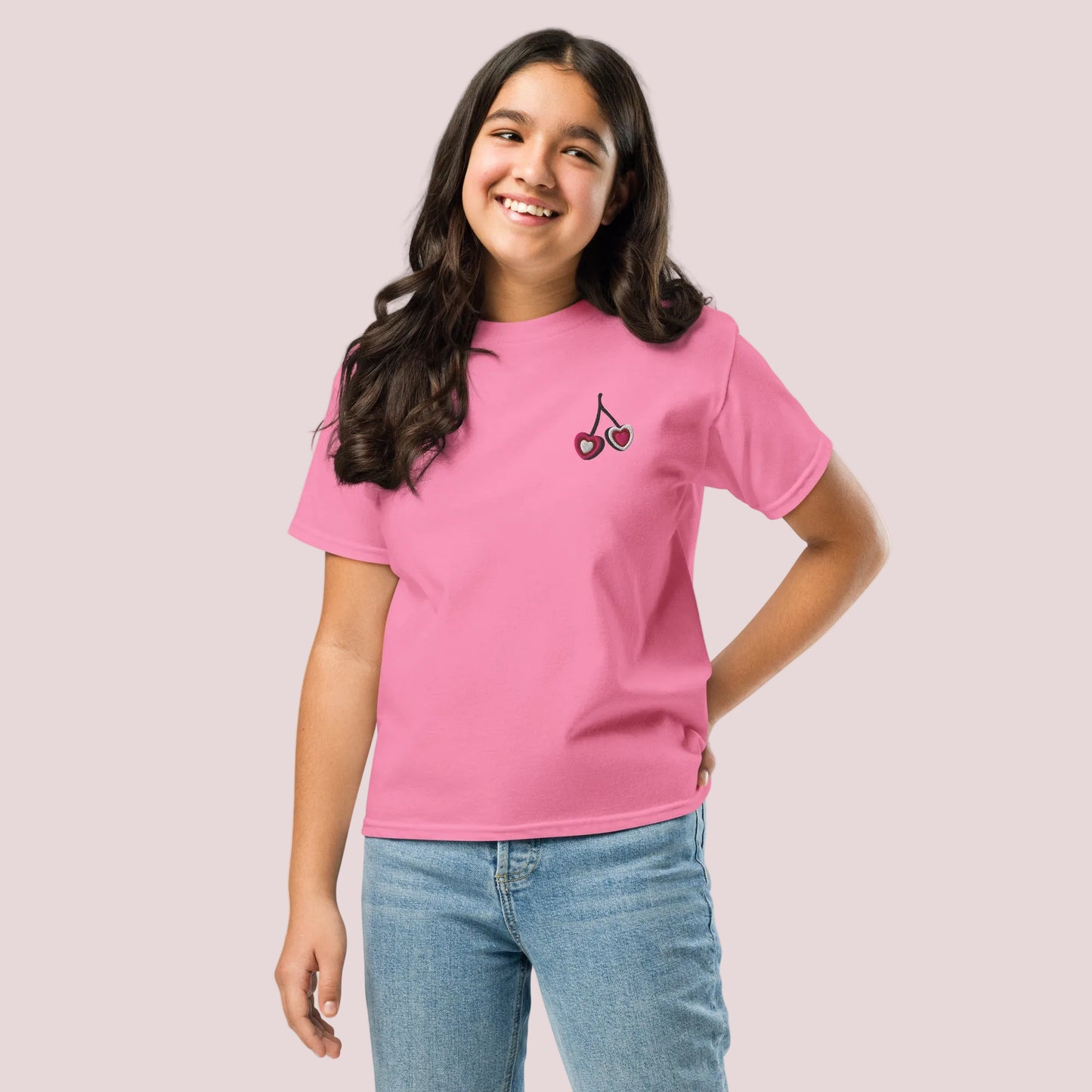 Soft cotton girls tshirt with delicate embroidered heart cherries on the chest, available in white, natural, and azalea. This lightweight top is perfect for spring and summer outfits, offering a mix of comfort and charm. The simple design makes it easy to style with shorts, skirts, or leggings, while the subtle coquette inspired detail adds a sweet, girly touch to everyday looks.