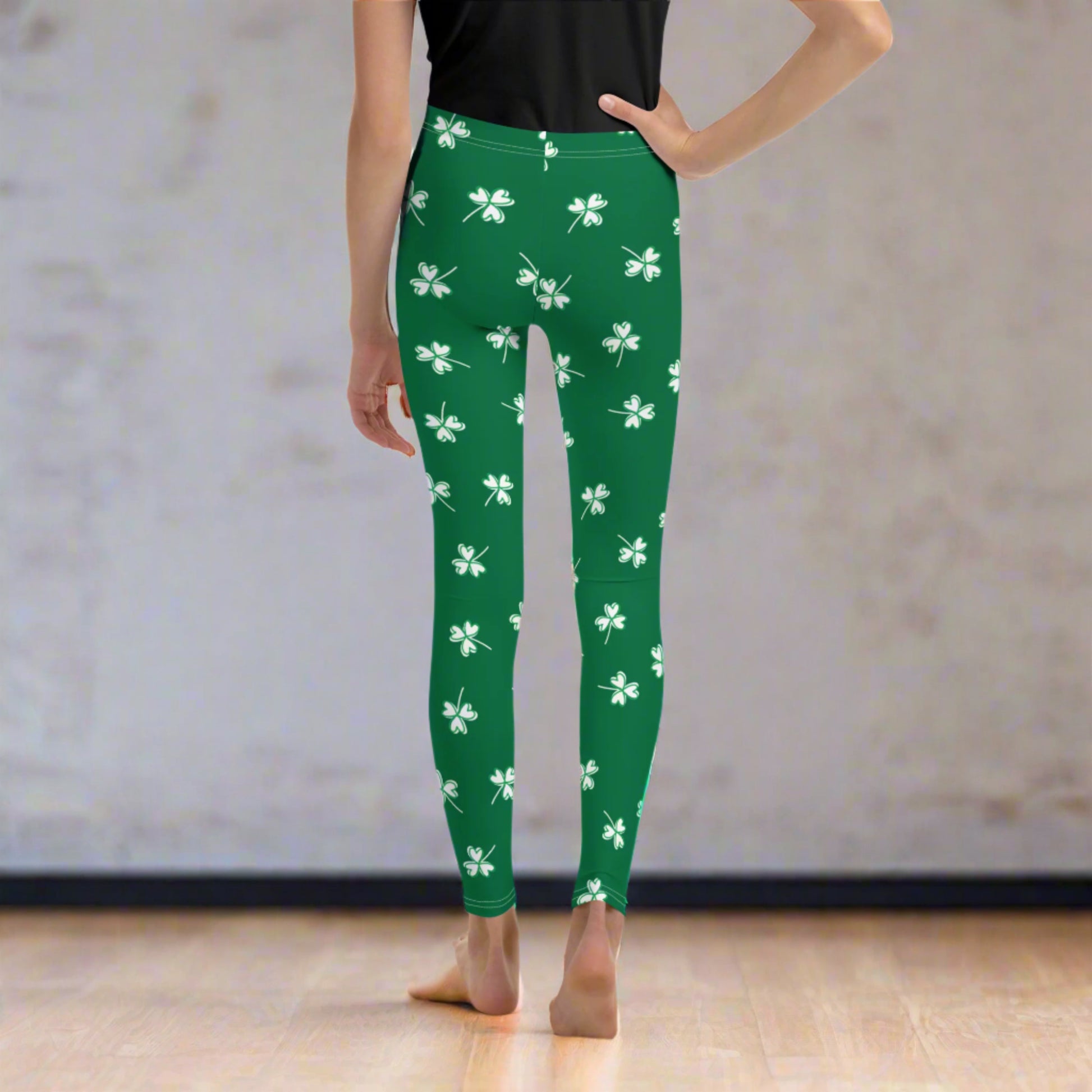 Image: Family Matching St Patricks Day Shamrock Leggings. Festive yoga pants with green background and white four leaf clovers. Available in sizes for toddler girls, teens, tweens, and women. Perfect for a St Pattys Day parade or fun run, by jaecrece