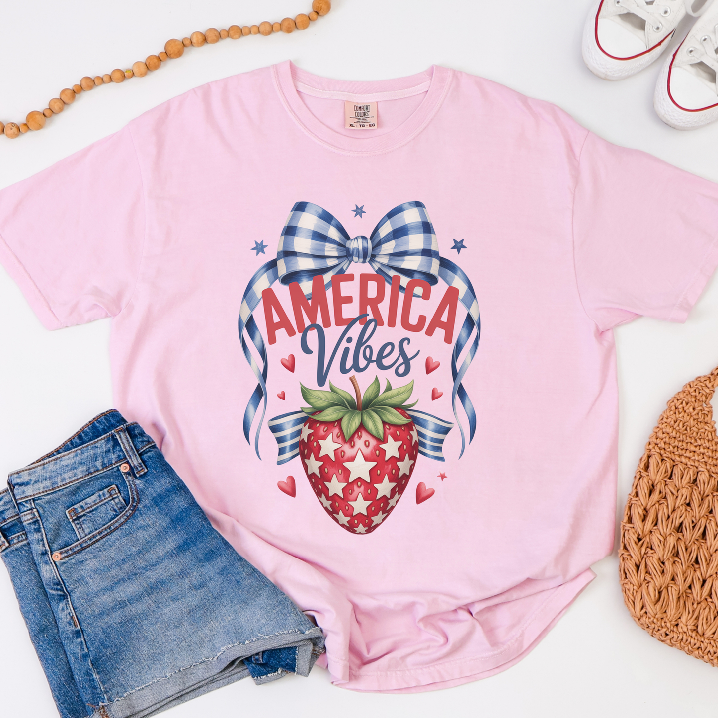 Girls patriotic strawberry Comfort Colors tee featuring a vintage Americana design with strawberry artwork patriotic stars heart details and gingham bow accents. America 250 inspired youth t shirt with relaxed fit for comfortable everyday wear. Perfect for 4th of July celebrations mommy and me matching outfits patriotic family vacations Memorial Day events and summer holiday photos