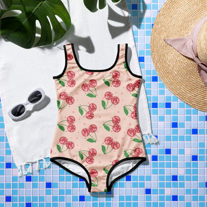 Girls vacation swimsuit with a pink cherry print, retro disco details, and a fun one piece design for beach days and pool parties.