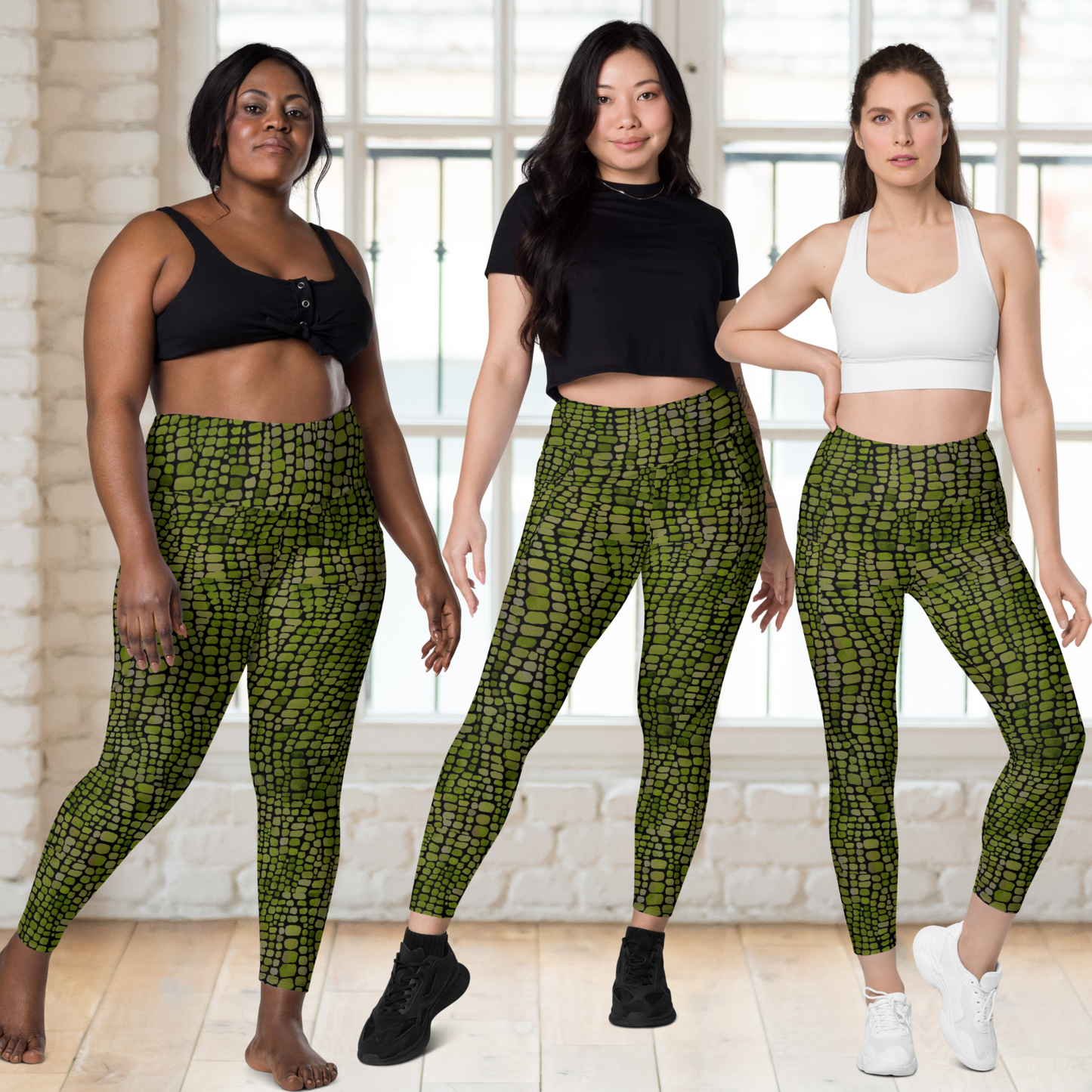 Three women wearing green snake skin patterned leggings in a studio setting.