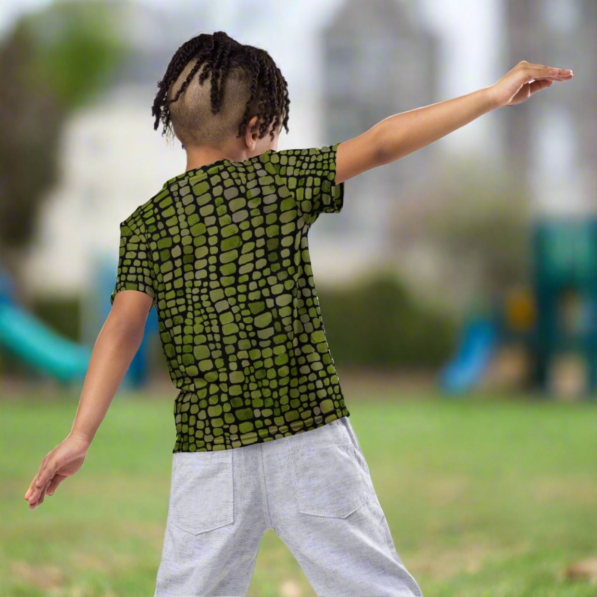 Green reptile scale kids shirt in toddler sizes 2T–7, designed for use in dinosaur, lizard, and snake costumes. This all-over printed tee makes a perfect base layer for creative play and Halloween fun. Lightweight, breathable, and easy to move in, it's a favorite for kids who love reptiles, jungle animals, and pretend play. Great for both boys and girls and pairs well with other costume accessories.