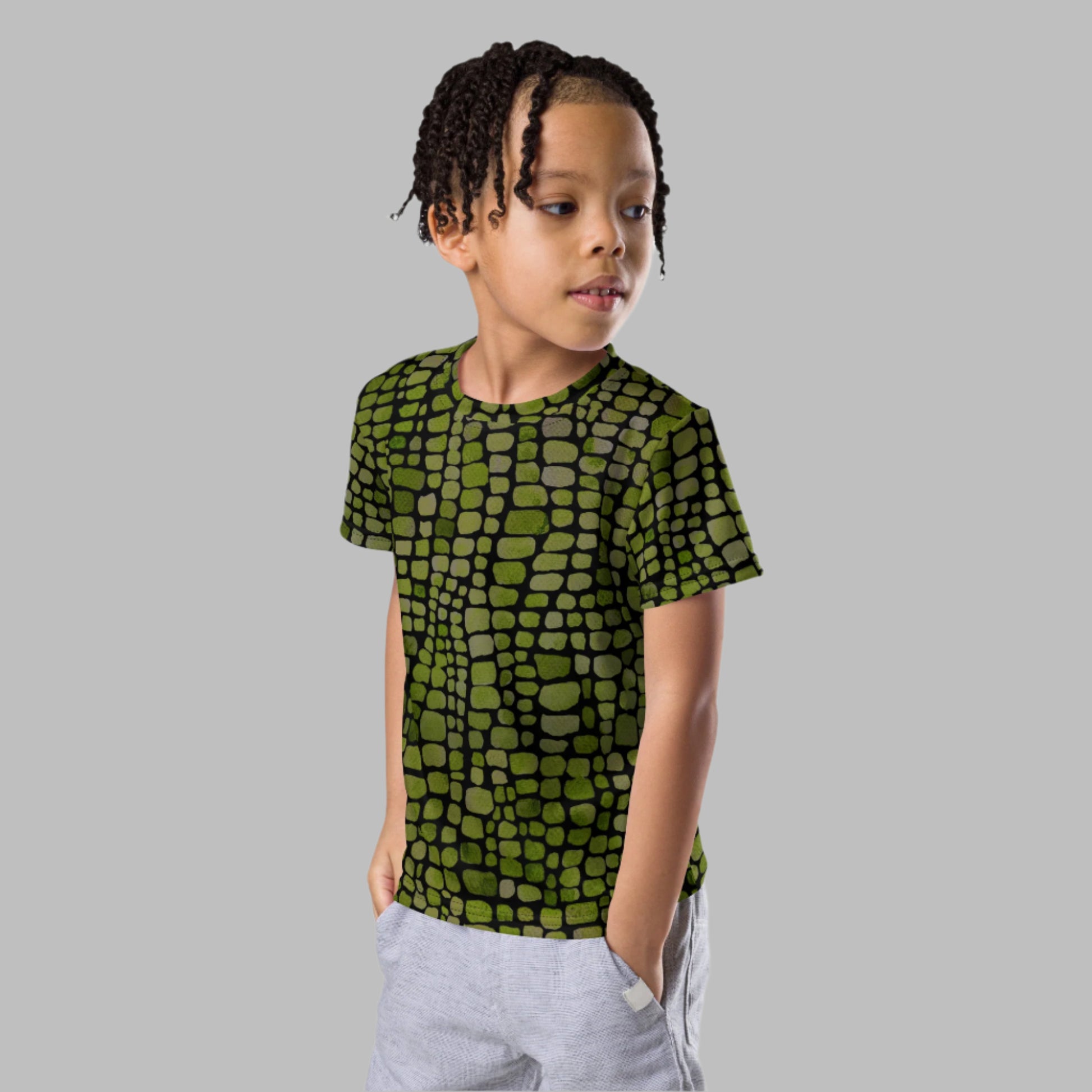 Kids all-over print reptile t-shirt in green scale design, available in toddler sizes 2T–7. Perfect for dinosaur, snake, serpent, or lizard costumes, this unisex tee is soft, stretchy, and fun for everyday dress-up. Whether worn to a themed party, Halloween event, or as a gift for animal-loving kids, this shirt is a great choice for wild, imaginative playtime or classroom costume days.