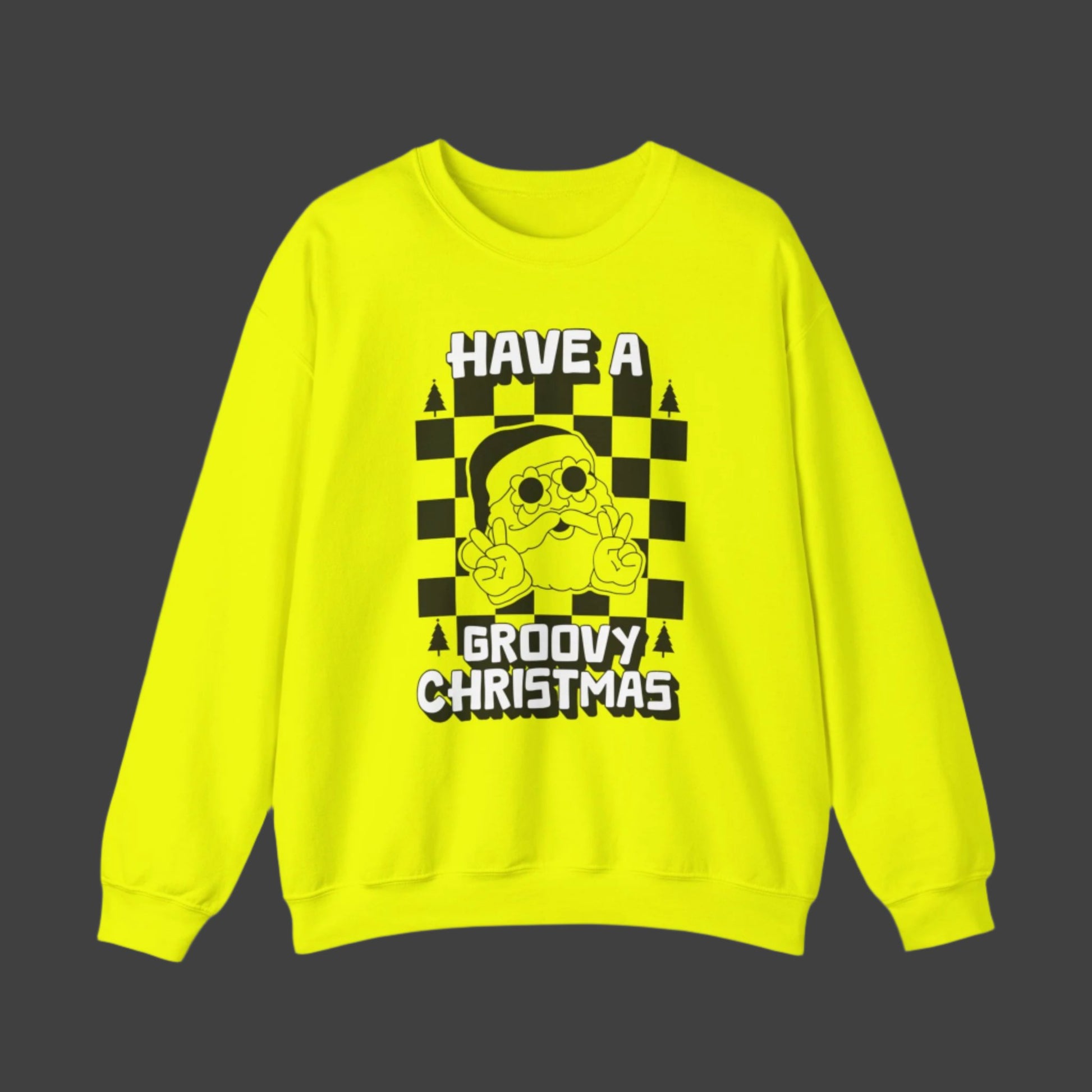 Groovy Christmas sweatshirt with retro Santa graphic wearing daisy sunglasses and giving a peace sign. White block lettering reads “Have a Groovy Christmas” over a bold checkerboard background. Printed on Gildan 18000 in Safety Pink or Safety Green, this cozy crewneck is soft, warm, and designed for holiday fun. Ideal for Christmas parties, festive family gatherings, retro outfit lovers, or as a quirky Christmas gift in unisex sizes S–5XL.
