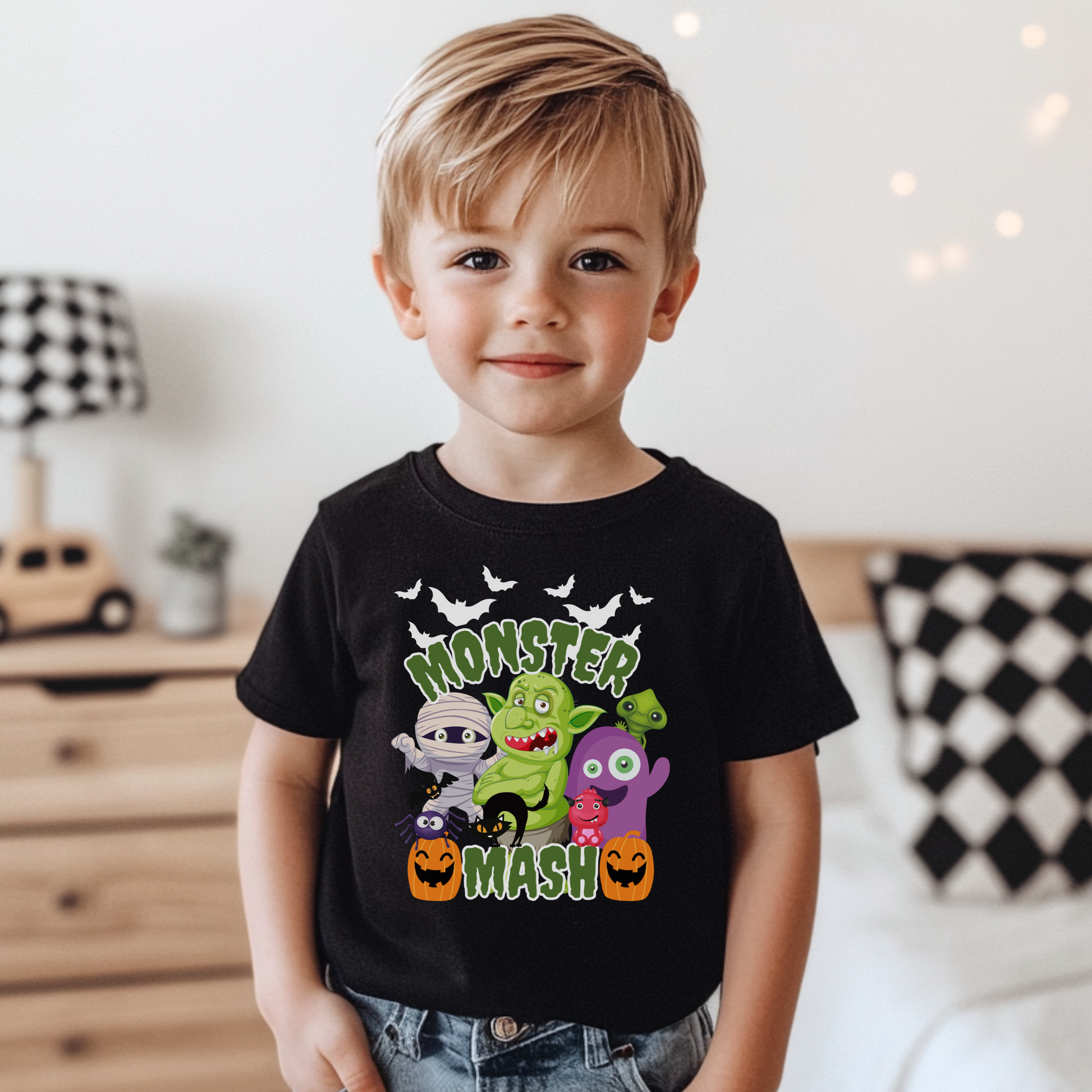 Monster Mash Halloween t shirt featuring a fun cartoon group of spooky characters including bats, zombie, troll, mummy, ghost, black cat, and pumpkins printed on a black Bella Canvas tee. The design includes bright green slime Monster Mash lettering for a playful Halloween look, perfect for kids, youth, and adults. Great for pumpkin patch trips, trick or treating, school parties, and matching family Halloween outfits.