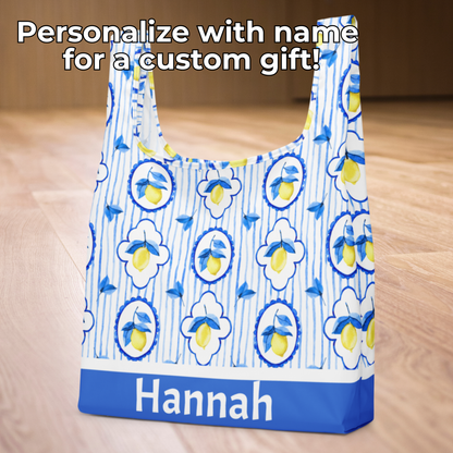 Amalfi Lemon Tote Bag brings Mediterranean charm to everyday errands with its vibrant lemon and tile print. Eco friendly and reusable, this washable tote is made with strong straps integrated into the design so they won’t snap, even with heavy use. Measuring 15.5" × 25.3", it folds neatly with an elastic band, making it ideal for groceries, farmers markets, and travel. A thoughtful gift for her, teachers, and moms.