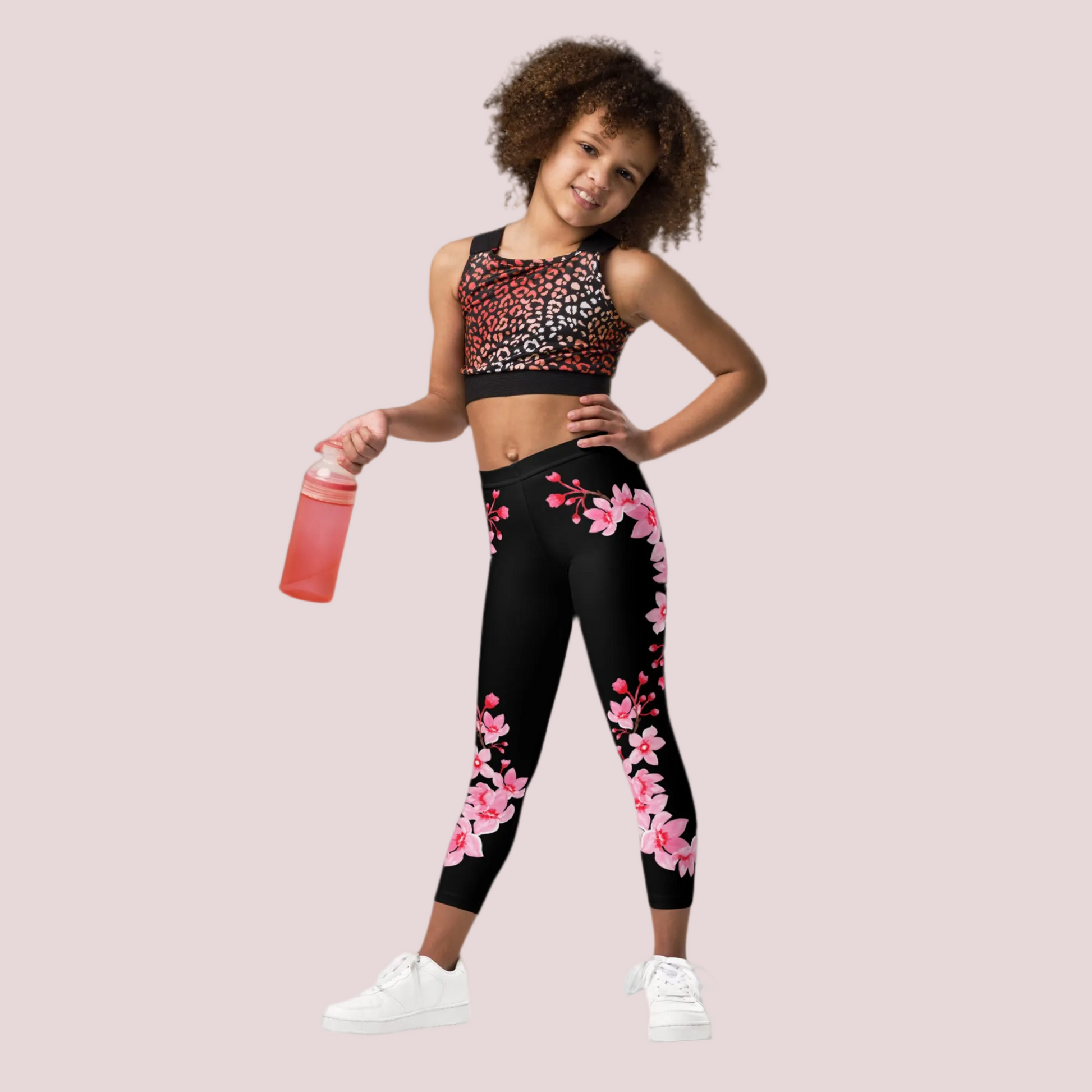 Kids black leggings featuring delicate cherry blossom flowers in a soft pink design along the legs, high rise waistband and ankle length fit for comfort and flexibility, made for active girls who love playful and stylish outfits, soft stretch fabric ideal for school days, weekend outings, or lounging at home, Japanese inspired floral design that adds a gentle aesthetic touch to everyday kids fashion and coordinated sibling looks