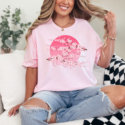 Women’s graphic t-shirt featuring a pink moon and Japanese cherry blossom tree, perfect for fans of kawaii fashion, sakura season, and Japanese aesthetic style. This soft girl inspired shirt blends pastel colors with nature motifs, offering a dreamy, feminine look ideal for spring outfits or casual wear. Great gift for her, this sakura and moon tee fits soft aesthetic lovers, Japanese art fans, and women’s floral clothing seekers. Tags: cherry blossom shirt, pink moon shirt, sakura t-shirt.
