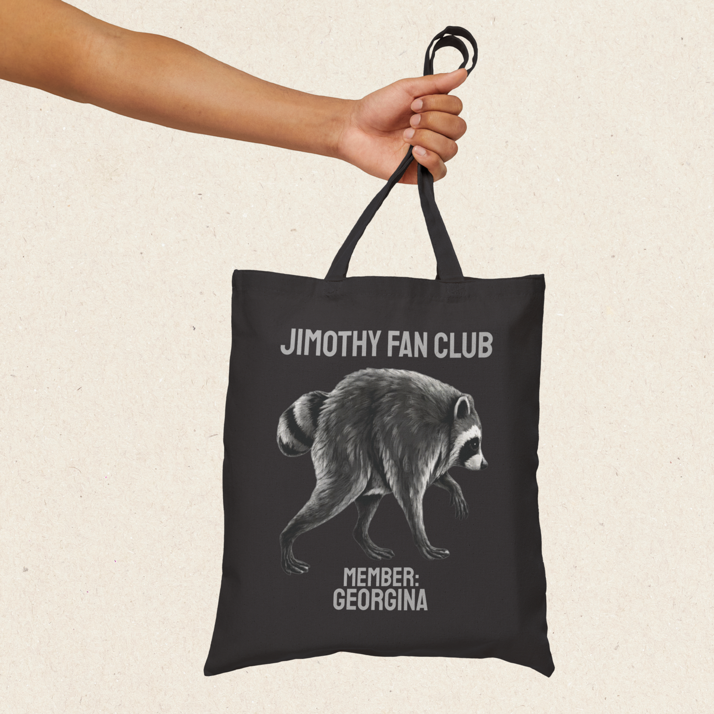 Jimothy Fan Club tote bag with personalized MEMBER name beneath a detailed raccoon illustration. Custom Jimothy gift featuring vintage inspired lettering on a heavyweight cotton canvas tote for raccoon lovers, animal lovers, meme fans, and Seattle raccoon enthusiasts.
