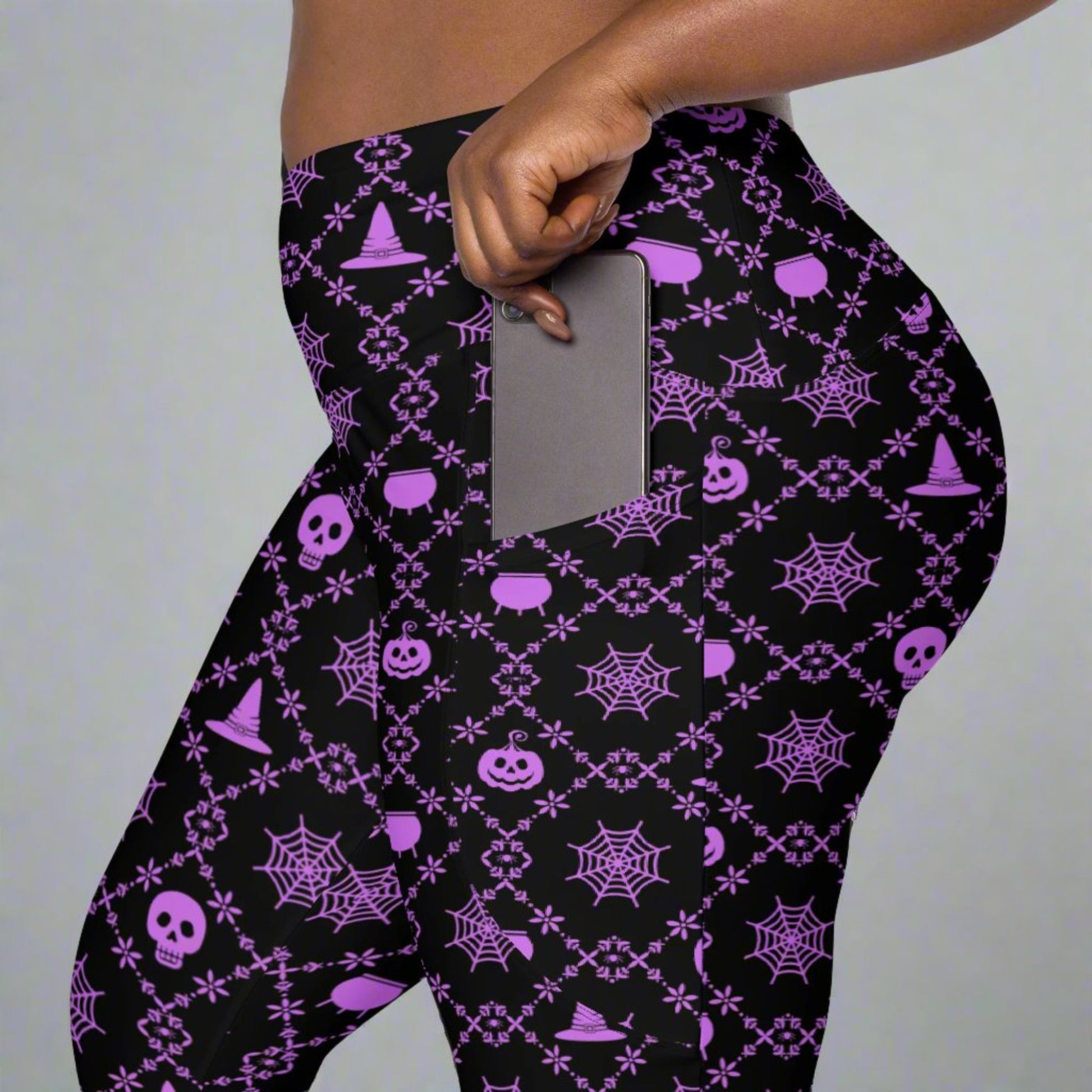 Wickedly Cute Ladies Halloween Leggings, featuring a black material with a purple geometric pattern that consists of spiders webs, pumpkns, witches hats and skulls, by jaecrece.com