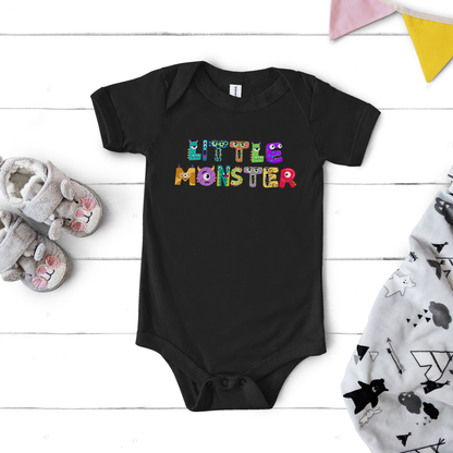 Flat lay of the black Little Monster baby bodysuit printed on a soft Bella + Canvas 100B, featuring playful cartoon monster letters spelling “little monster” across the chest. This infant one-piece is made from 100% combed ring-spun cotton with a lightweight feel, envelope neckline, and three-snap leg closure for easy diaper changes. Perfect for baby’s first Halloween, a fall baby shower gift, or everyday wear, available in newborn through 24 months.