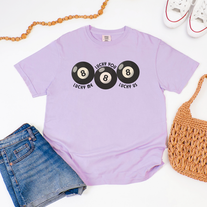 Retro 8 ball graphic tee on Orchid Comfort Colors shirt with Lucky Me Lucky You Lucky Us wording in bold curved print. Premium cotton unisex top with relaxed fit, soft garment dyed fabric, and timeless vintage style. Thoughtful present for anniversaries, weddings, engagement parties, Valentine celebrations, or couples who love matching shirts. Easy to style with denim shorts, leggings, joggers, sneakers, and everyday basics.
