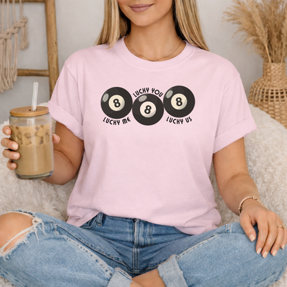 Blossom garment dyed Comfort Colors graphic shirt featuring Lucky Me Lucky You Lucky Us phrase and retro triple 8 ball artwork. Soft premium cotton tee with unisex relaxed fit designed for comfort and style. Ideal for matching couple looks, anniversary presents, wedding gifts, honeymoon outfits, Valentine plans, or modern streetwear wardrobes. Vintage inspired statement tee with playful energy and easy everyday versatility.