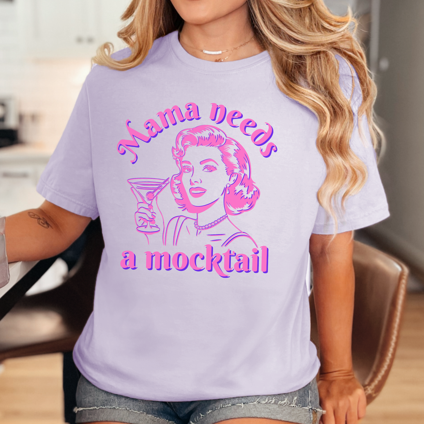 Image: A stylish and humorous Mama Needs a Mocktail shirt, designed with a vintage pop art mom holding a cocktail glass in bright pink neon. Available in six soft colors, this Comfort Colors tee is a great way to celebrate recovery, sobriety, or a sober curious lifestyle. Ideal for baby showers, pregnancy announcements, or as a fun gift for a friend embracing alcohol free living, by jaecrece.