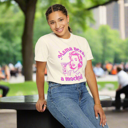 Image: A vintage inspired Mama Needs a Mocktail tee, featuring a playful pop art design of a retro mom toasting with a cocktail glass in bright pink neon. This Comfort Colors shirt is available in six chic shades, making it a perfect gift for sober curious friends, expecting moms, or those embracing a healthier lifestyle. A fun conversation starter that celebrates recovery and mindful drinking, by jaecrece.