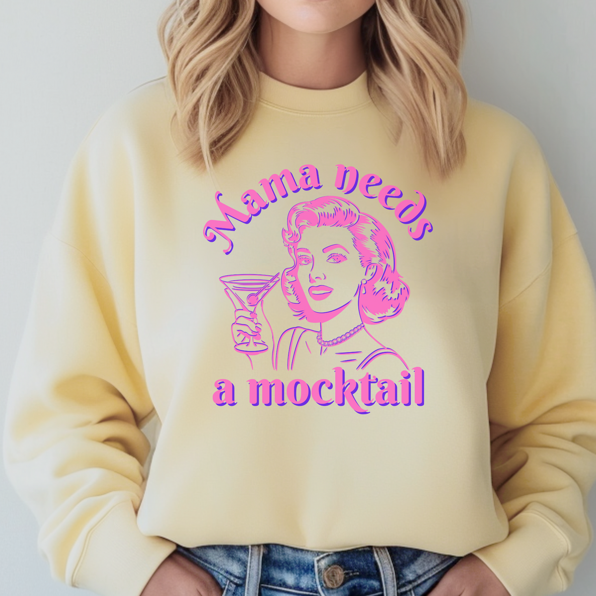 Comfort Colors crewneck sweatshirt featuring a colorful retro pop art graphic of a woman holding a cocktail glass with the phrase “Mama Needs a Mocktail” above and below the illustration. The bold pink and blue artwork creates a playful vintage inspired look on the soft sweatshirt. This fun design is perfect for moms who love mocktails, expecting moms, sober curious women, and anyone who enjoys a little humor in their wardrobe.