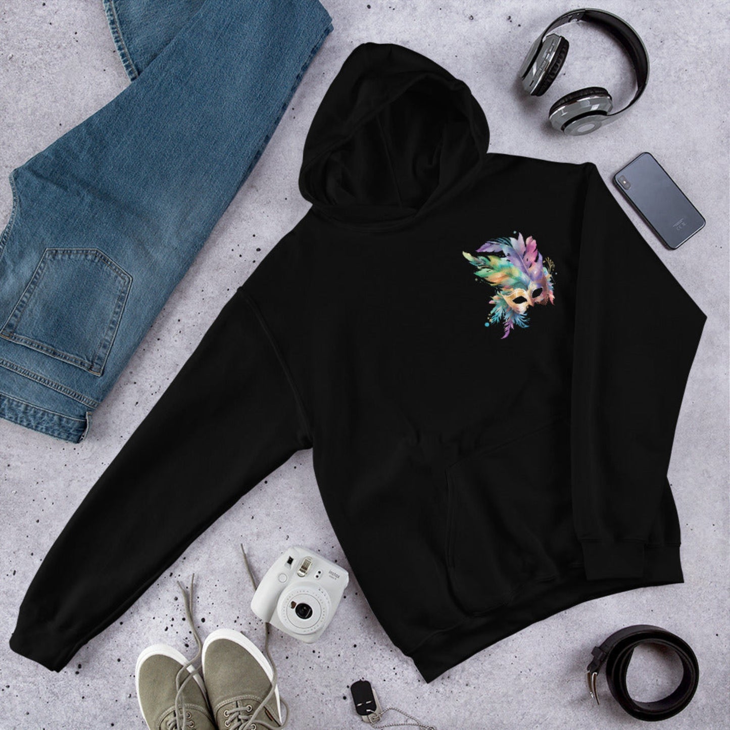 Image: Black Adult Mardi Gras Hoodie, printed on front and back. The front of the sweatshirt has a watercolor carnival mask, and the back features an oversized graphic of the same party mask with the text Laissez les on temps rouler, by jaecrece
