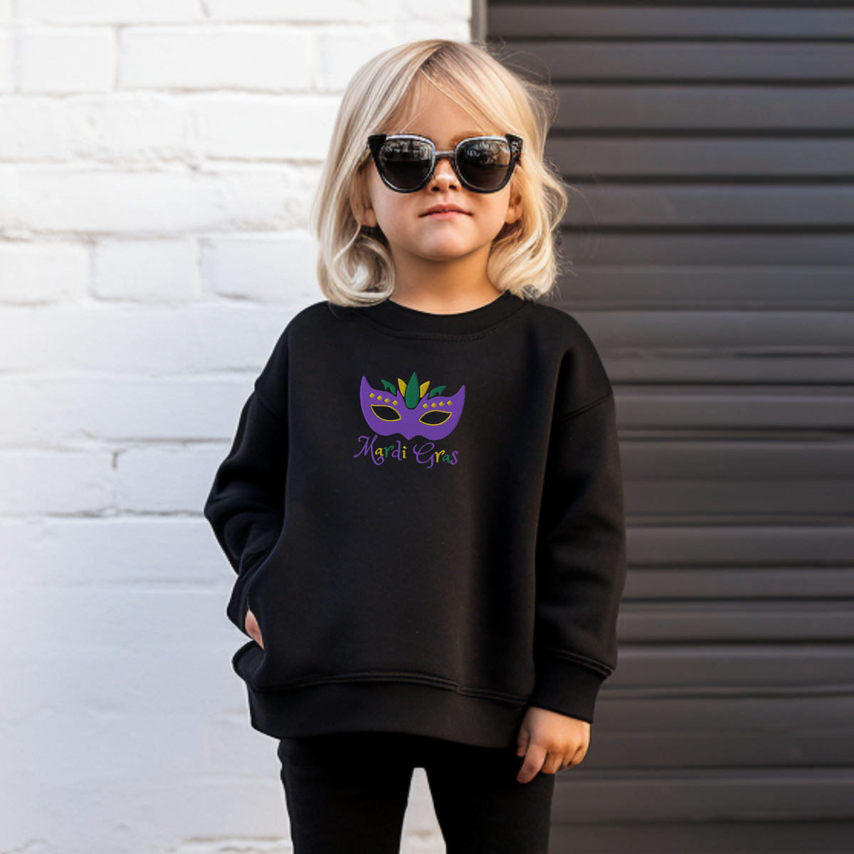 This youth Mardi Gras sweatshirt in sizes XS–XL features an embroidered carnival mask in vibrant purple, green, and gold with the text “Mardi Gras.” Perfect for parade day, school parties, or festive family celebrations. This kids Mardi Gras shirt is part of a matching family Mardi Gras outfit collection, making it ideal for coordinated holiday looks. Great for anyone searching for embroidered Mardi Gras kids clothes or festive New Orleans-inspired fashion.

