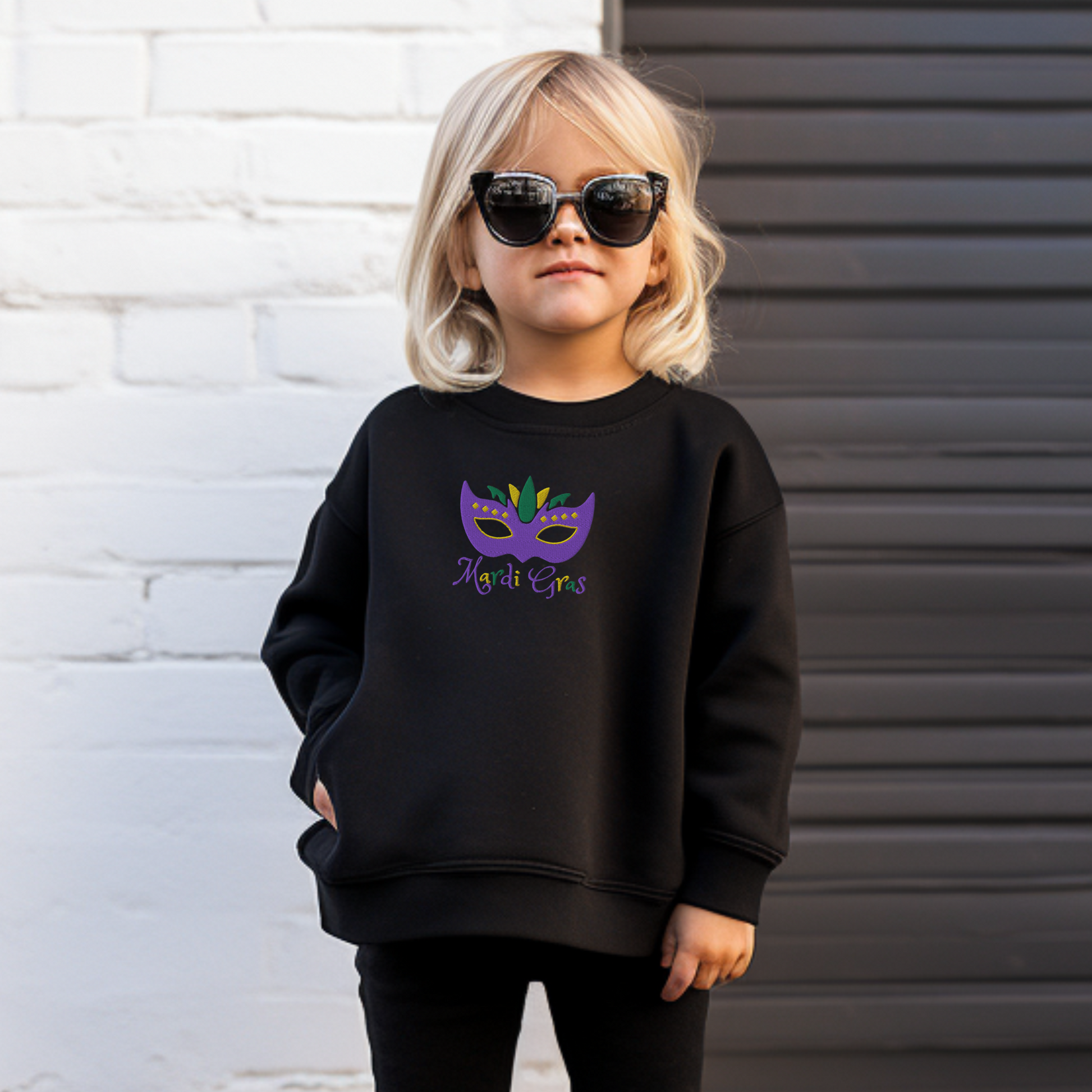 This youth Mardi Gras sweatshirt in sizes XS–XL features an embroidered carnival mask in vibrant purple, green, and gold with the text “Mardi Gras.” Perfect for parade day, school parties, or festive family celebrations. This kids Mardi Gras shirt is part of a matching family Mardi Gras outfit collection, making it ideal for coordinated holiday looks. Great for anyone searching for embroidered Mardi Gras kids clothes or festive New Orleans-inspired fashion.

