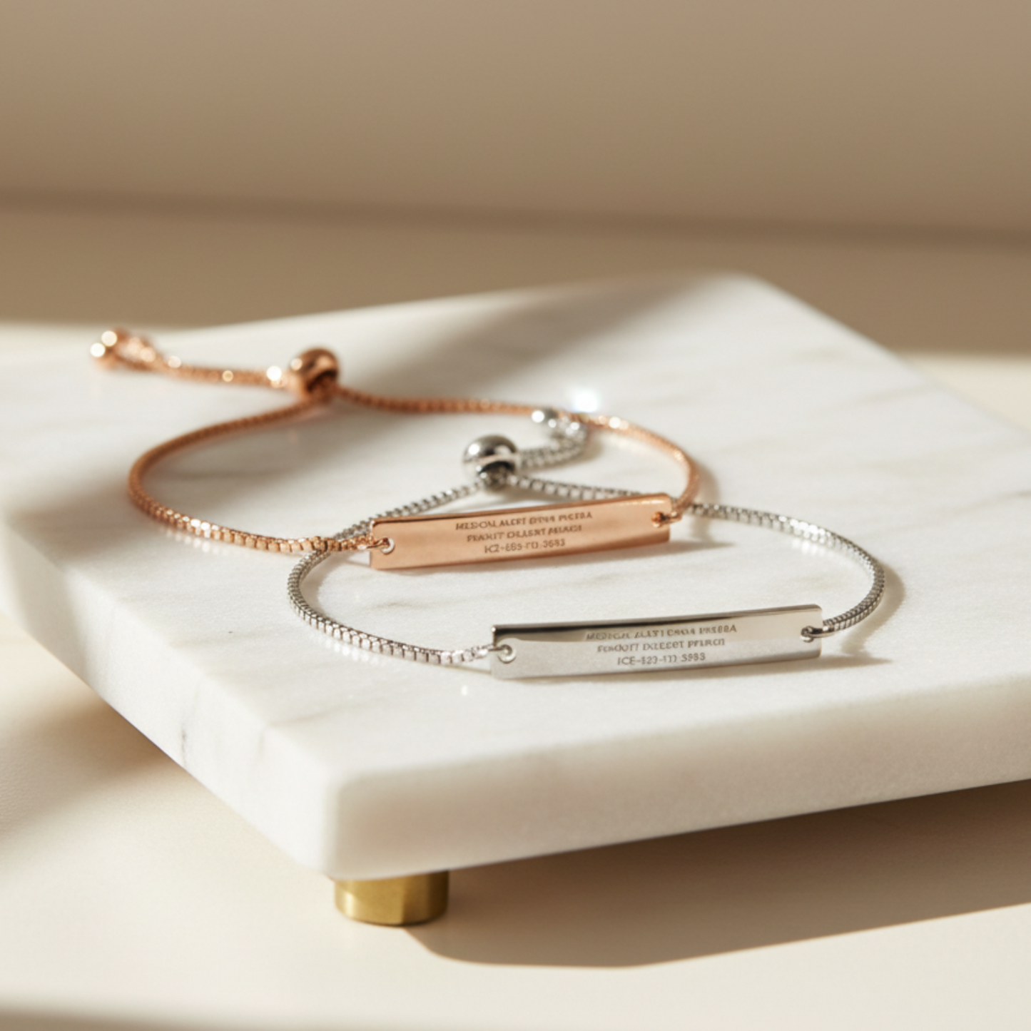 Two personalized medical ID bracelets in rose gold and silver shown together with engraved medical conditions and emergency contact information. Adjustable bracelets for adults and teens.