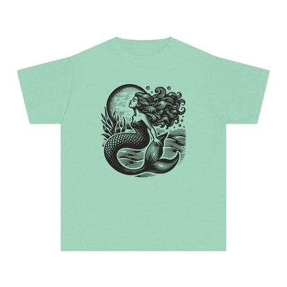 Mermaid aesthetic girls shirt with a linocut inspired ocean art design featuring a mystical mermaid beneath a glowing moon and textured sea waves. Soft Comfort Colors youth tee with a vintage garment dyed finish and relaxed classic fit for comfortable all day wear. Perfect for coastal aesthetic wardrobes beach vacations summer adventures matching mommy and me outfits and nautical inspired fashion. Great gift idea for girls who love ocean themes seaside style and whimsical graphic tees.