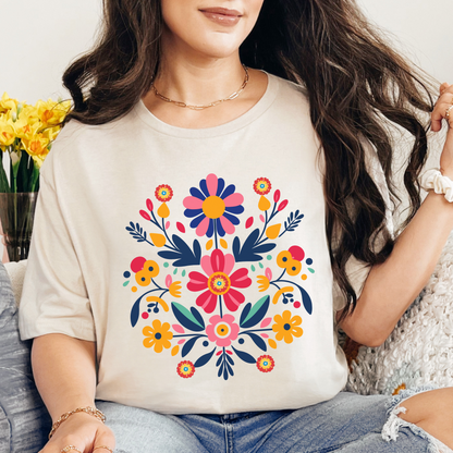 Natural colored Gildan 64000 Softstyle tee featuring a colorful Otomi inspired Mexican folk art floral design. The warm neutral shirt creates a softer backdrop for the bright flowers and detailed artwork, giving this Mexican folk art shirt a relaxed bohemian feel while keeping the colorful design at the center. A fun choice for everyday wear, cultural celebrations, Hispanic Heritage Month, and family outings