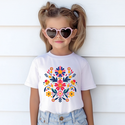 Girls’ Otomi Folk Art T-shirt with vibrant floral print in sizes XS to XL. This colorful Mexican-inspired shirt features a bold botanical graphic rooted in traditional Otomi embroidery. Made from midweight US cotton, this girls’ crew neck tee is ideal for birthdays, holidays, family reunions, and everyday wear. Perfect for parents seeking cultural kidswear, artisan fashion, or soft boho cotton tops for stylish girls.