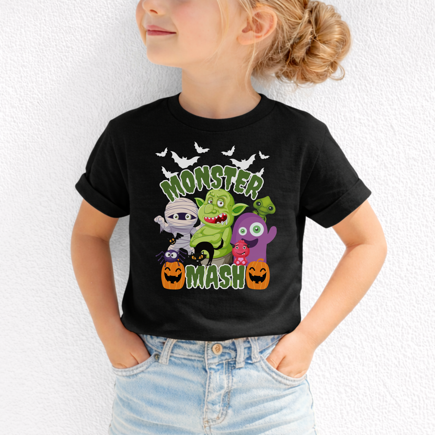 Monster Mash Halloween tee featuring a colorful cartoon spooky scene with bats, zombies, trolls, mummy, ghost, black cat, and pumpkins on a black Bella Canvas shirt. Green slime lettering gives a fun playful look, making this a perfect Halloween shirt for kids, youth, and adults. Ideal for pumpkin patch outings, school events, trick or treating, fall festivals, and matching family Halloween outfits.