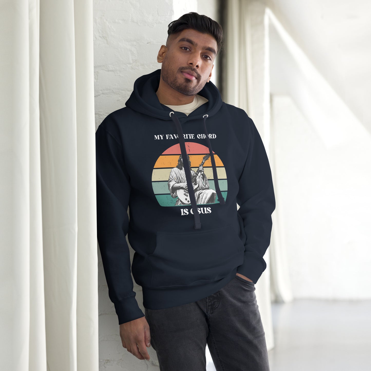 A man wearing the “My Favorite Chord Is GSUS” unisex hoodie, styled casually to highlight the relaxed fit and faith inspired humor. This cozy fleece hoodie features a clever Christian music pun, perfect for guitar players, worship leaders, and choir members. Made with a soft cotton polyester blend and available in sizes S–3XL, it’s ideal for jam sessions, church events, or everyday comfort.

