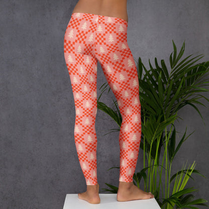 Women's leggings with a nostalgic Nordic inspired Christmas pattern featuring cream evergreen trees and red geometric designs against a pink background. The sweater inspired print creates a cozy winter aesthetic without the traditional red and green color palette. The full length design makes these leggings easy to pair with sweaters, sweatshirts, tees, boots, or casual shoes throughout the holiday season.