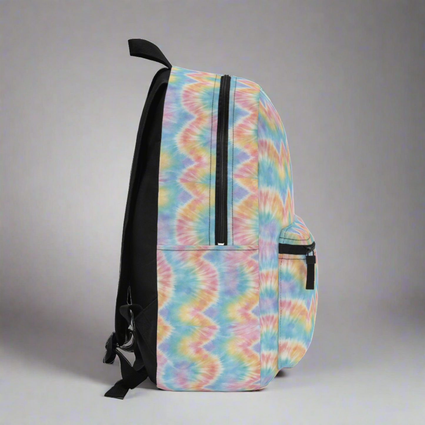 Side detail of pastel tie dye backpack highlighting the colorful swirl design and spacious structure. This trendy aesthetic backpack is designed for students, teens, and travelers who want a stylish yet functional bag. The soft pastel tie dye pattern gives a fun retro vibe while the roomy interior holds books, tech, and daily essentials. Cute tie dye school backpack, colorful pastel bookbag, aesthetic teen backpack, lightweight travel backpack, trendy tie dye bag for school.