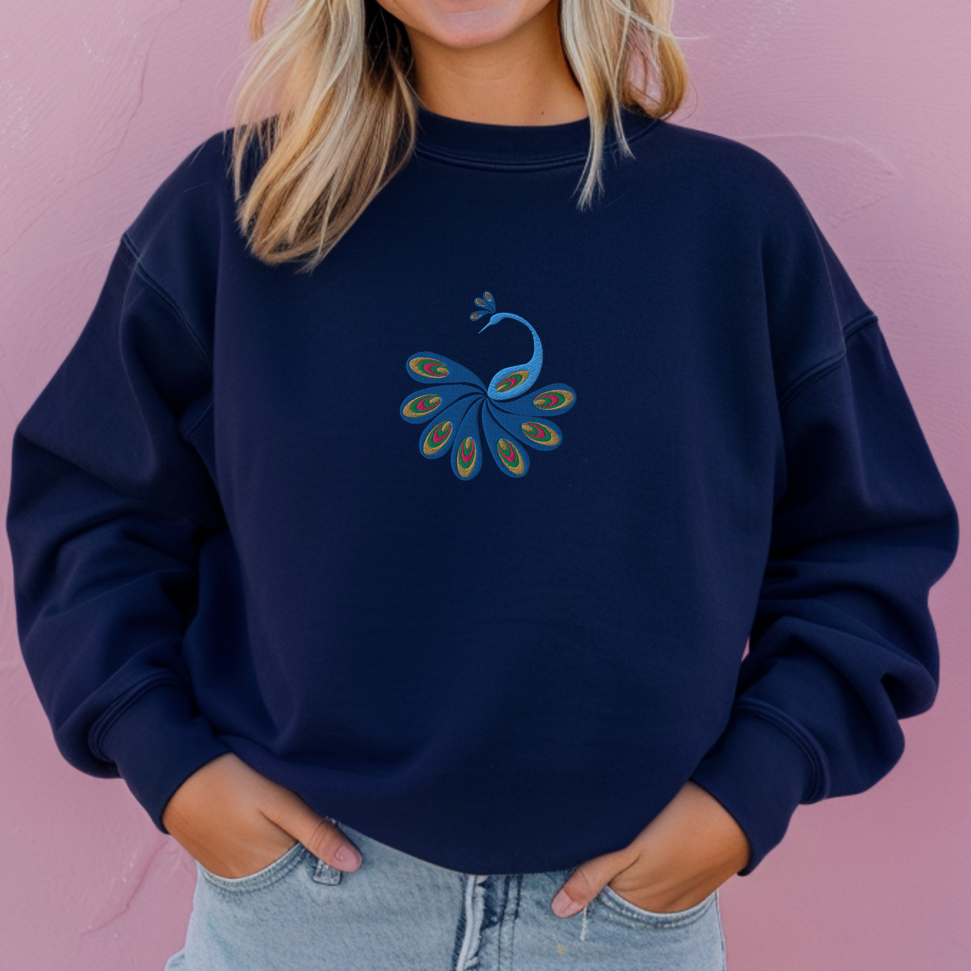 Image: A stylish women's sweatshirt featuring an intricately embroidered peacock with vivid feathers, blending earthy tones and rich blues for a nature-inspired fashion statement. This boho pullover is ideal for fall or spring layering, offering both comfort and charm. A must-have for bird lovers and fashionistas alike, this sweatshirt adds flair to your everyday wardrobe while celebrating art, nature, and bold femininity, by jaecrece.