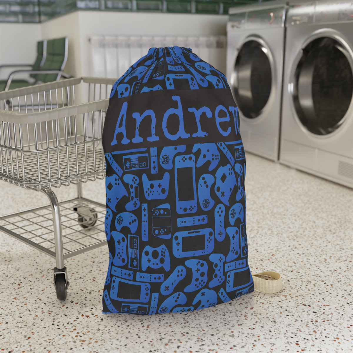 Personalized blue and black gamer laundry bag featuring a playful pattern of video game controllers and handheld consoles. Custom name text makes this reusable laundry bag a fun choice for boys, girls, kids, teens, sleepaway camp, college dorms, travel, or keeping dirty clothes organized at home.