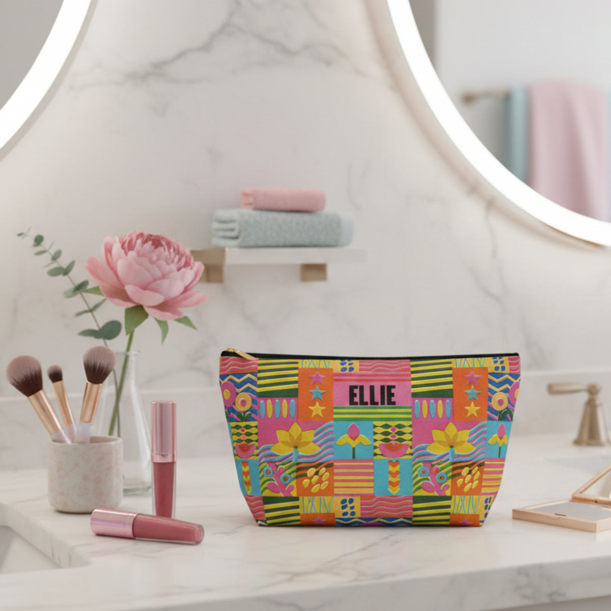 Personalized retro floral makeup bag featuring a colorful patchwork design with cheerful flowers, wavy lines, stripes, stars, and geometric shapes. The custom name is displayed prominently across the front of this playful cosmetic pouch. Its bright colors and whimsical pattern make it a fun accessory for girls, tweens, teens, or anyone who loves colorful maximalist style.