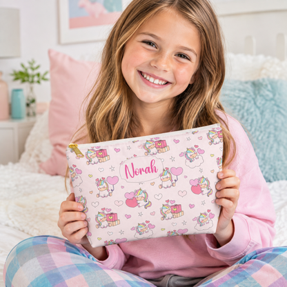 Happy girl holding a personalized pink unicorn zipper pouch with her name, pastel rainbow details, hearts, stars and whimsical unicorn design, ideal for girls makeup, toiletries, school supplies, travel and sleepovers