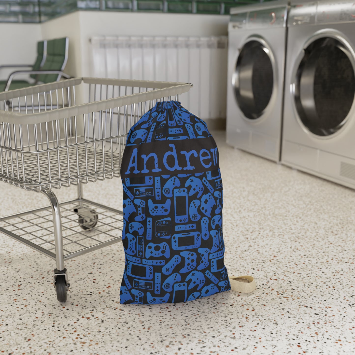 Personalized gaming laundry bag in blue and black with an all over pattern inspired by video game controllers and handheld consoles. Designed for kids and teens who love gaming, this reusable bag can hold dirty clothes for camp, dorms, sleepovers, family trips, or everyday laundry organization.