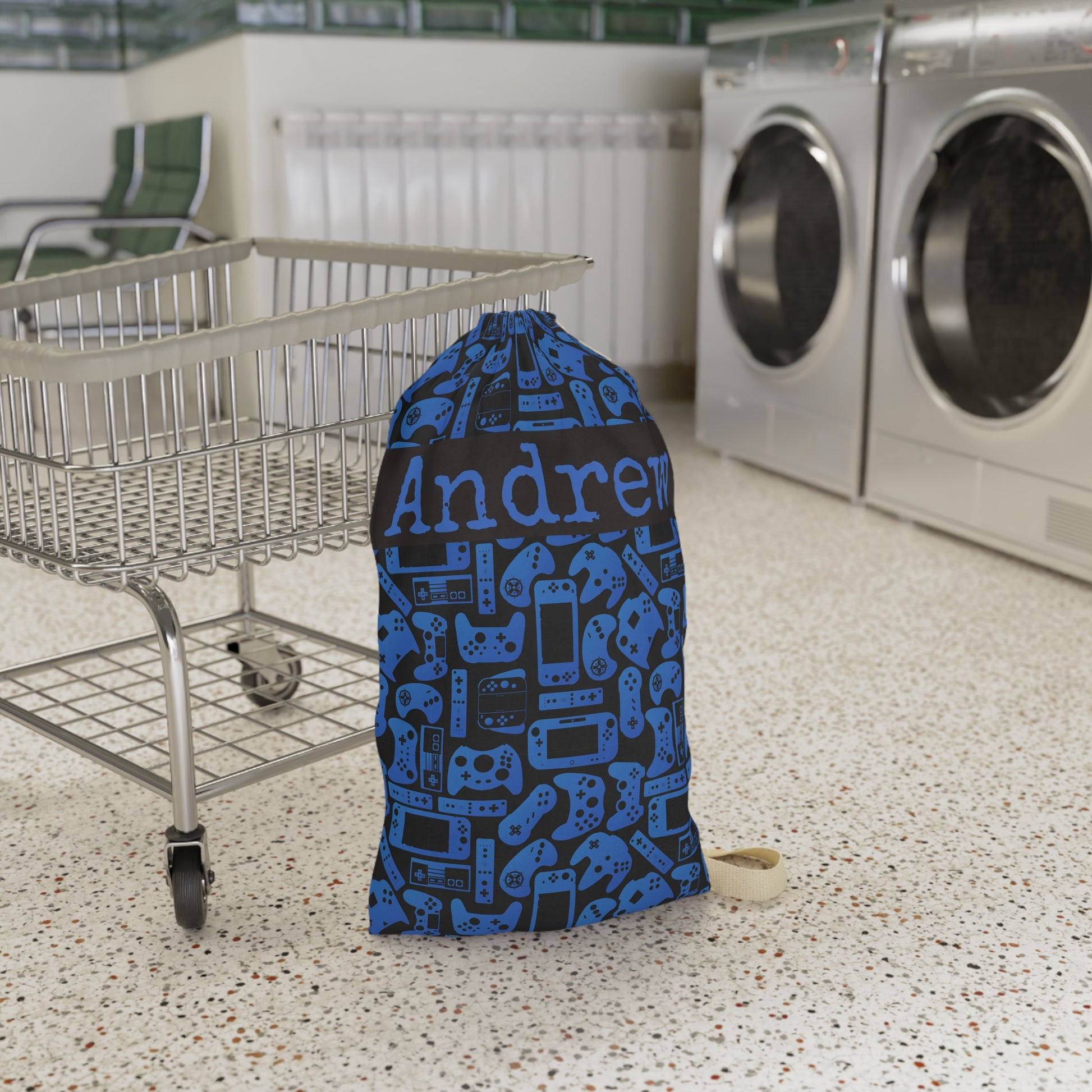 Personalized gaming laundry bag in blue and black with an all over pattern inspired by video game controllers and handheld consoles. Designed for kids and teens who love gaming, this reusable bag can hold dirty clothes for camp, dorms, sleepovers, family trips, or everyday laundry organization.