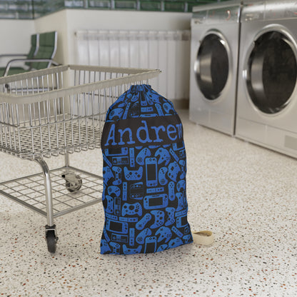 Personalized gaming laundry bag in blue and black with an all over pattern inspired by video game controllers and handheld consoles. Designed for kids and teens who love gaming, this reusable bag can hold dirty clothes for camp, dorms, sleepovers, family trips, or everyday laundry organization.