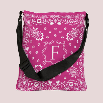 Personalized hot pink bandana tote bag with a classic white paisley pattern and custom monogram. Features an adjustable shoulder and crossbody strap, black interior lining with inside pocket, and a spacious design for work, travel, shopping, beach days, and everyday use.