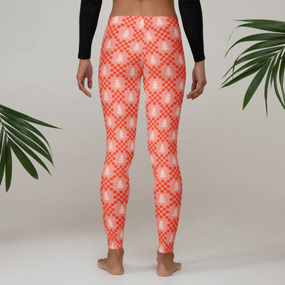 Pink Christmas tree leggings with a playful pattern of cream evergreen trees and red geometric details on a soft pink background. The nostalgic holiday design makes these women's leggings a fun gift idea for someone who loves Christmas clothing, cozy winter fashion, or unique holiday prints. The full length style and comfortable mid rise waistband make them practical as well as festive.